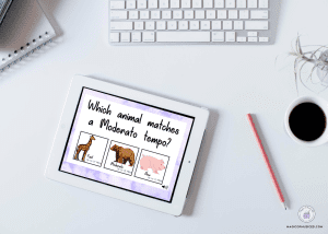 Image of a digital tablet displaying a music listening quiz about animal tempos and a notebook with pencils on a white desk.