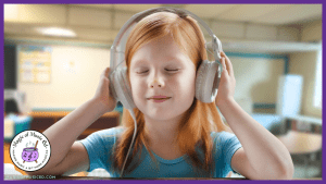 A young girl sits listening peacefully to music in her elementary music class. Through listening to music, music teachers can help their auditory learners strengthen their rhythm and timing in music class.
