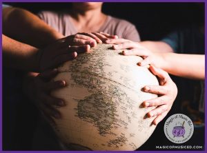 Hands from a group of people resting on a globe, representing unity and celebrating cultures around the world. Perfect for a multicultural choir concert theme.