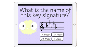 A tablet displaying an interactive key signature identification Boom Cards™ activity. The screen features a pastel purple background, a cute monster character, a musical staff with flats, and multiple-choice answer options for identifying the key signature.