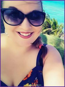 Music teacher smiling by a tropical ocean view, representing the joy of teaching Caribbean music and ocean songs during the end of the school year.