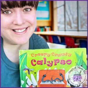 Elementary music teacher holding the storybook “Creepy Crawly Calypso” to introduce Caribbean music through storytelling.